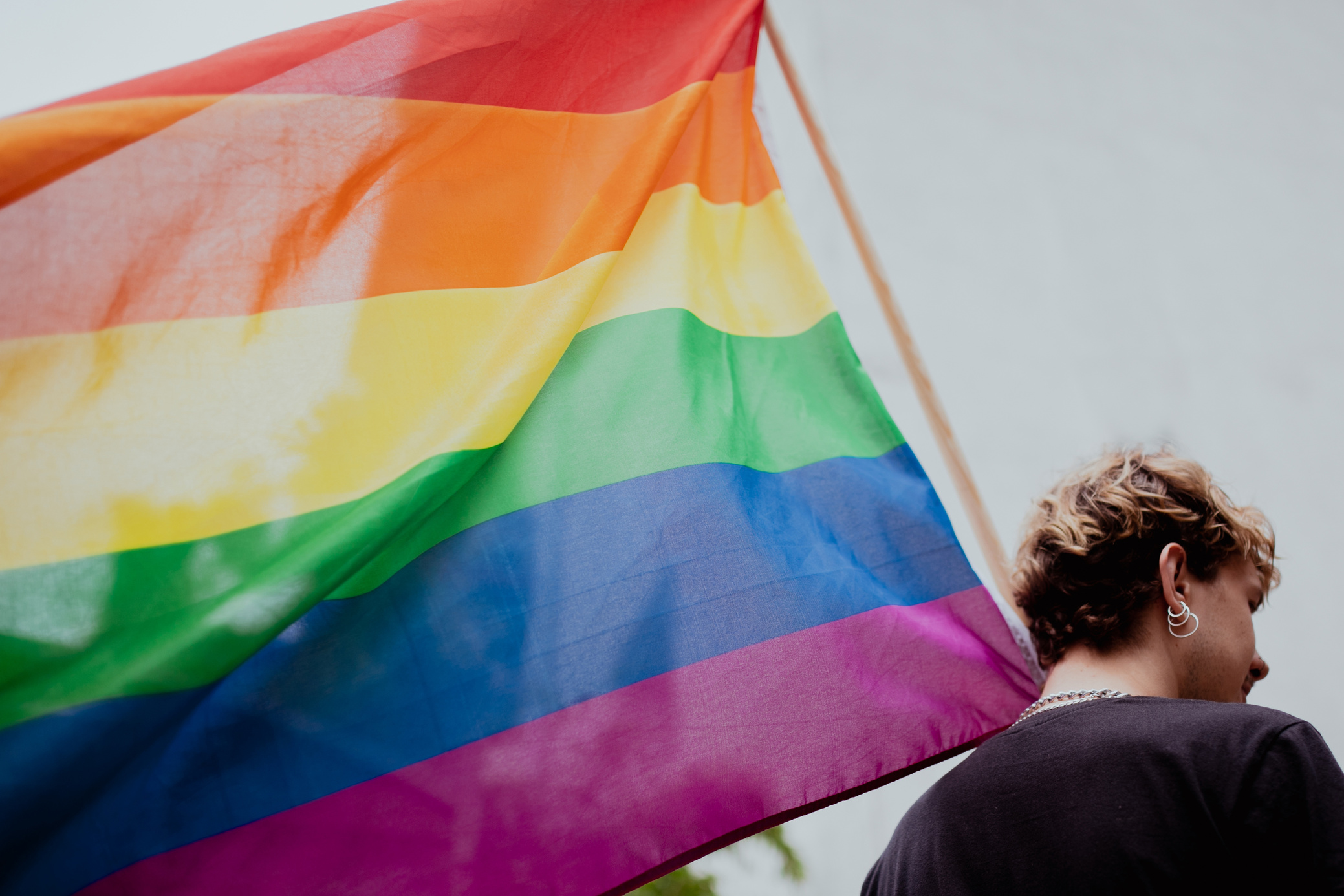 Person Holding a Traditional Gay Pride Flag 